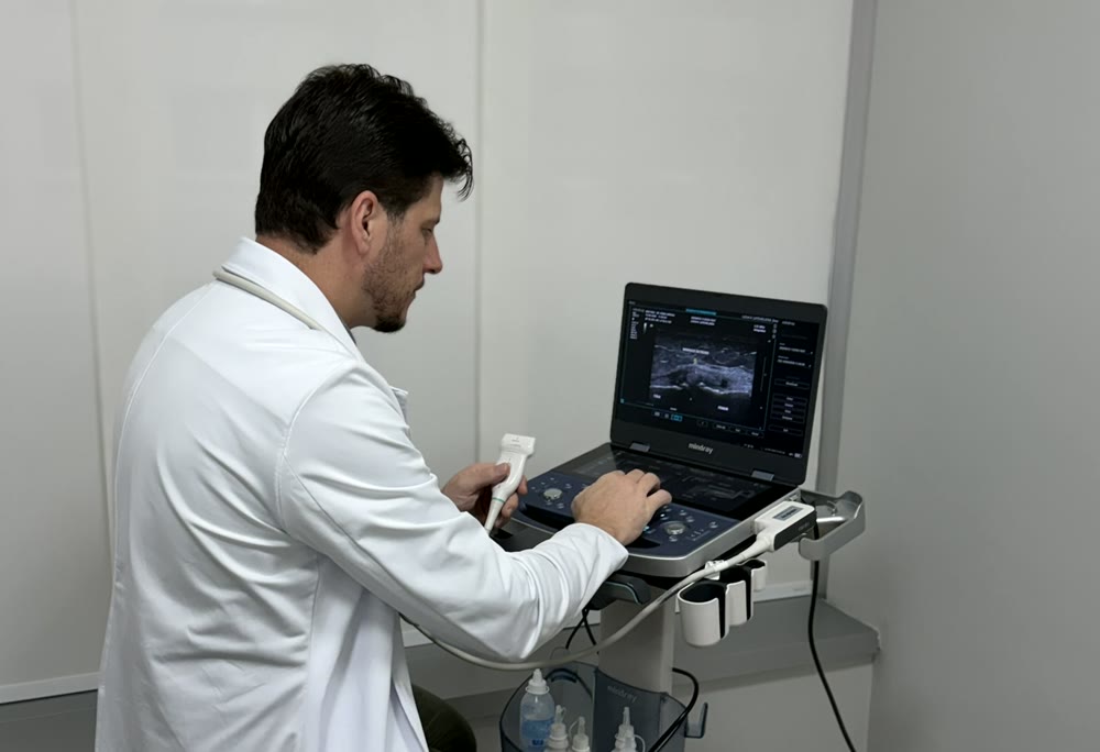 Dr. Rúbio Arruda realizando exame de ultrassom do joelho no consultório